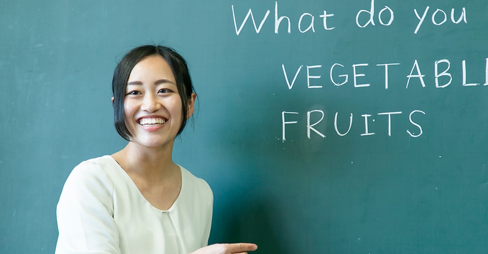 a smiling teacher engages with her students